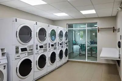a laundry room with four washing machines and a table at Residence Inn by Marriott Denver Southwest/Littleton in Littleton