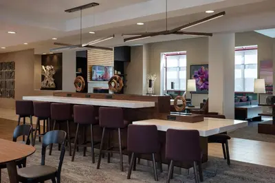 a lobby with a bar with chairs and tables at Courtyard by Marriott Denver Airport in Denver
