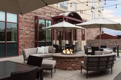 a patio with chairs and tables and umbrellas at Courtyard by Marriott Denver Airport in Denver