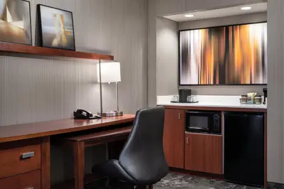 a room with a desk with a chair and a microwave at Courtyard by Marriott Boulder in Boulder