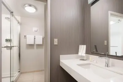 a bathroom with a sink and a mirror and a shower at Courtyard by Marriott Boulder in Boulder
