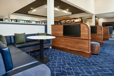 a room with a couch and a tv and a table at Courtyard by Marriott Boulder in Boulder
