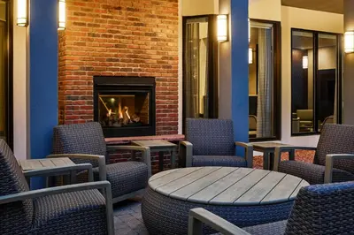 a room with chairs and a fireplace and a table at Courtyard by Marriott Boulder in Boulder