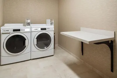 a laundry room with a washing machine and a counter at Courtyard by Marriott Boulder in Boulder