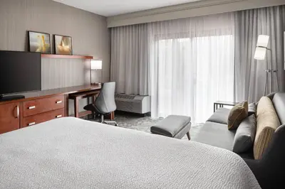 a hotel room with a bed and a flat screen tv at Courtyard by Marriott Boulder in Boulder