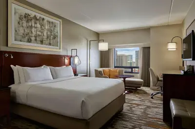 a hotel room with a large bed and a desk at Hilton Denver City Center in Denver