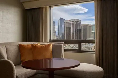 a living room with a couch and a table and a window at Hilton Denver City Center in Denver