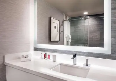 a bathroom with a white sink and a mirror at Hilton Denver City Center in Denver