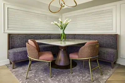 a dining room with a table with chairs and a vase of flowers at The Ritz-Carlton, Denver in Denver