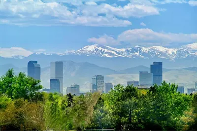 a city skyline with snow capped mountains in the background at Hotel Clio, a Luxury Collection Hotel, Denver Cherry Creek in Denver