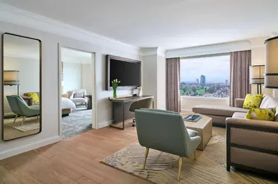 a living room with a couch and a bed and a mirror at Hotel Clio, a Luxury Collection Hotel, Denver Cherry Creek in Denver