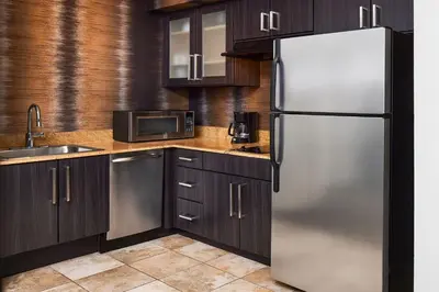 a kitchen with a stainless steel refrigerator and wooden cabinets at Residence Inn Denver City Center in Denver