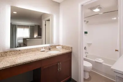 a bathroom with a sink and a toilet and a mirror at Residence Inn by Marriott Boulder in Boulder