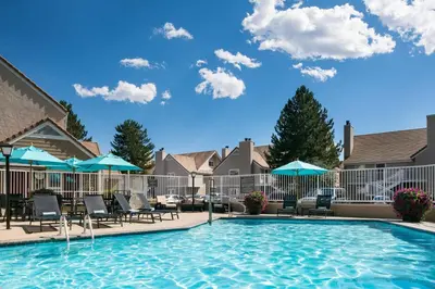 a swimming pool with chairs and umbrellas at Residence Inn by Marriott Boulder in Boulder