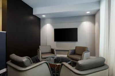 a waiting room with two chairs and a table and a tv at Courtyard Denver Tech Center in Greenwood Village