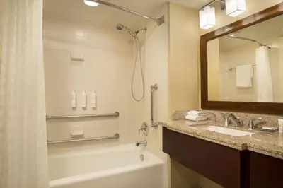 a bathroom with a tub and a sink and a mirror at Denver Marriott West in Golden