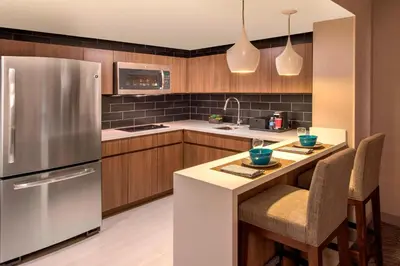 a kitchen with a stainless steel refrigerator and wooden cabinets at Denver Marriott Tech Center in Greenwood Village