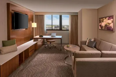 a living room with a couch and a table and a desk at Denver Marriott Tech Center in Greenwood Village