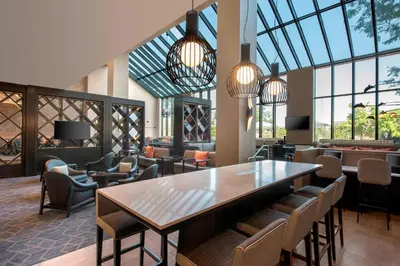 a lobby with a table and chairs and windows at Denver Marriott Tech Center in Greenwood Village