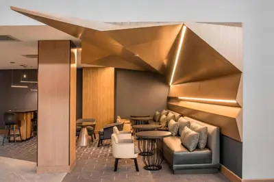a lobby with a couch and tables and a bar at Denver Marriott Tech Center in Greenwood Village