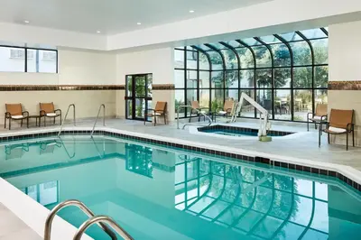 a pool in a hotel with chairs and tables at Courtyard by Marriott Fort Collins in Fort Collins