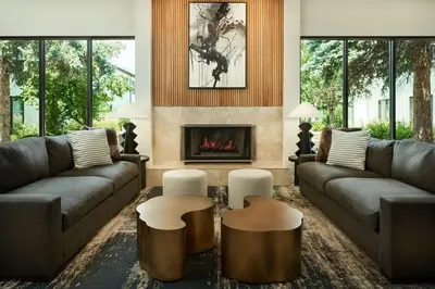 a living room with two couches and a fireplace at Courtyard by Marriott Fort Collins in Fort Collins