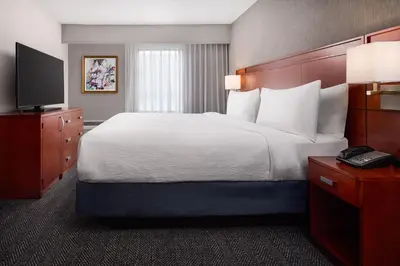 a hotel room with a large bed and a television at Courtyard by Marriott Fort Collins in Fort Collins