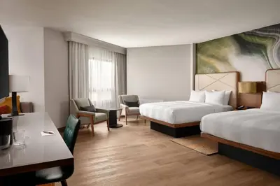 a hotel room with two beds and a desk at Fort Collins Marriott in Fort Collins