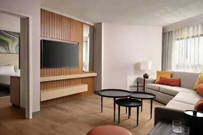 a living room with a couch and a tv at Fort Collins Marriott in Fort Collins
