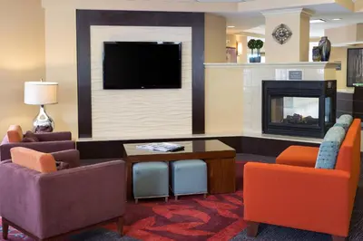 a living room with a tv and a fireplace at Residence Inn by Marriott Fort Collins in Fort Collins