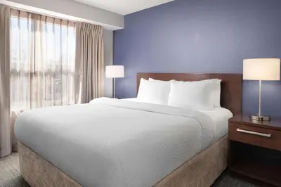 a bedroom with a large bed and a large window at Residence Inn by Marriott Fort Collins in Fort Collins