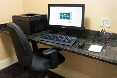a desk with a computer monitor and a keyboard and mouse at Residence Inn by Marriott Fort Collins in Fort Collins