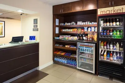 a grocery store aisle with a cashier and a shelf of drinks at Residence Inn by Marriott Fort Collins in Fort Collins
