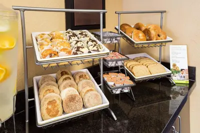 a display case with different types of pastries and bread at Residence Inn by Marriott Fort Collins in Fort Collins