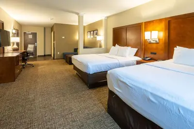 a hotel room with two beds and a desk at Comfort Suites Denver near Anschutz Medical Campus in Aurora