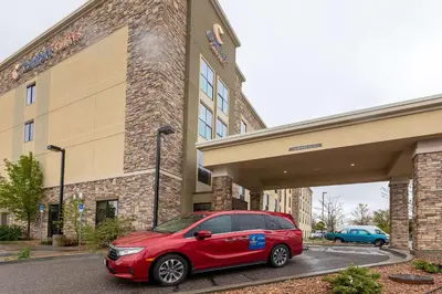a red car parked in front of a building at Comfort Suites Denver near Anschutz Medical Campus in Aurora