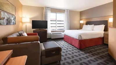 a hotel room with a bed and a television at TownePlace Suites by Marriott Denver Downtown in Denver