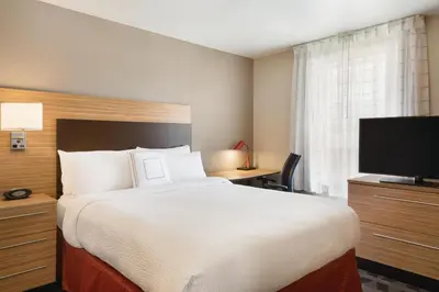 a hotel room with a bed and a flat screen tv at TownePlace Suites by Marriott Denver Downtown in Denver