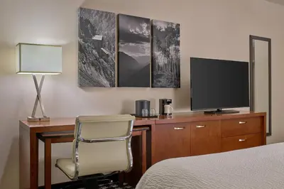 a hotel room with a desk with a television and a chair at Courtyard by Marriott Denver Downtown in Denver