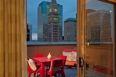 a red table and chairs on a balcony with a clock tower at Courtyard by Marriott Denver Downtown in Denver