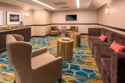 a waiting room with a couch and chairs and a tv at Courtyard by Marriott Denver Downtown in Denver