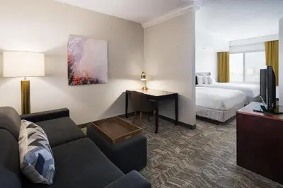 a hotel room with a couch and a bed and a desk at SpringHill Suites by Marriott Denver Airport in Denver