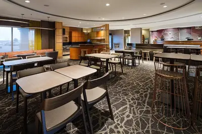 a restaurant with tables and chairs and a bar at SpringHill Suites by Marriott Denver Airport in Denver