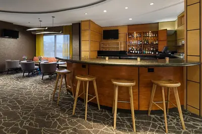 a bar in a hotel room with bar stools at SpringHill Suites by Marriott Denver Airport in Denver