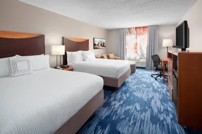 a hotel room with two beds and a desk at Fairfield Inn & Suites Denver Airport in Denver