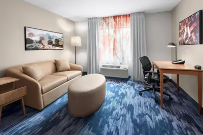 a living room with a couch and a desk at Fairfield Inn & Suites Denver Airport in Denver