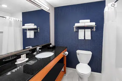a bathroom with a toilet and a sink and a mirror at Fairfield Inn & Suites Denver Airport in Denver