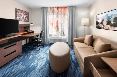 a living room with a couch and a desk at Fairfield Inn & Suites Denver Airport in Denver
