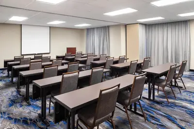a conference room with tables and chairs and a whiteboard at Fairfield Inn & Suites Denver Airport in Denver