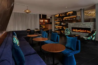 a lobby with a couch and tables and a fireplace at Renaissance Denver Hotel & Conference Center in Denver